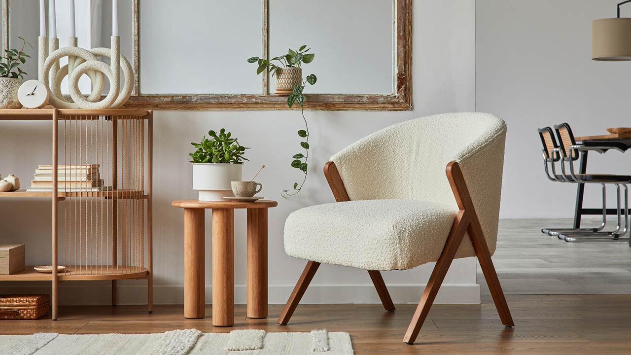 Stylish compositon of modern living room interior with frotte armchair, wooden commode, side table and elegant home accessories