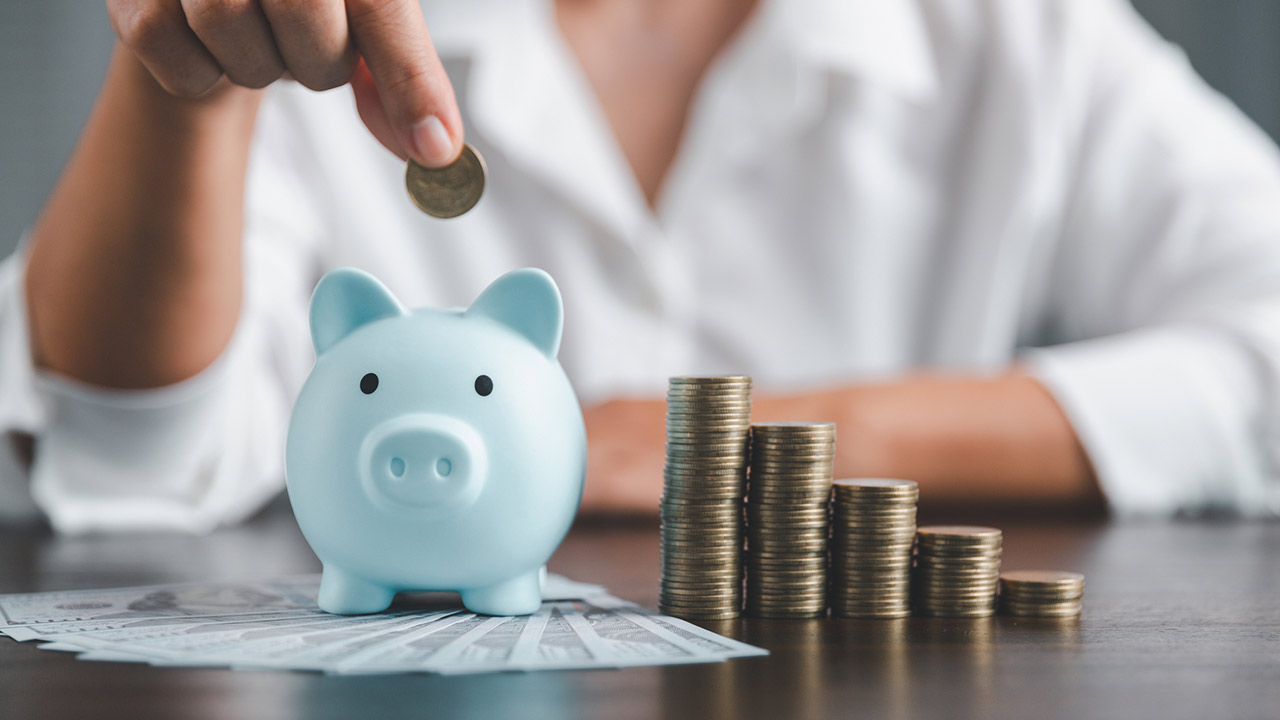 Saving investment banking finance concept. Stack of coins with piggy bank on the table