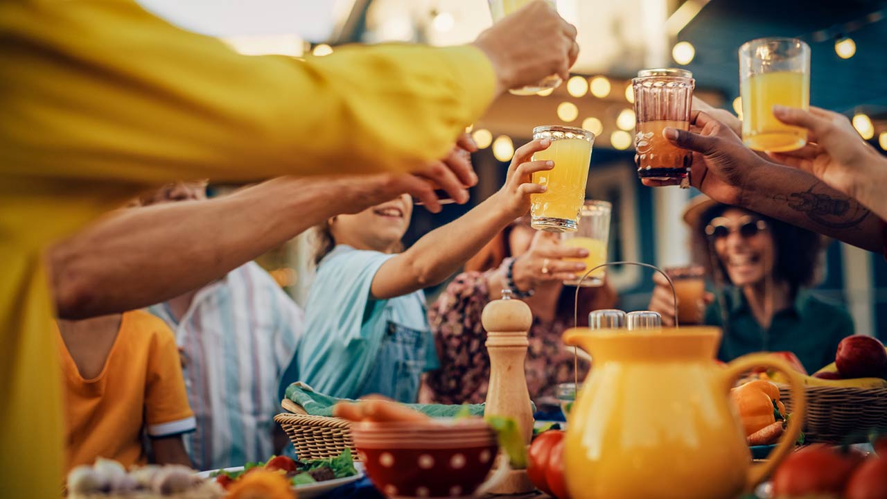 multicultural family and friends gathering together at a backyard party